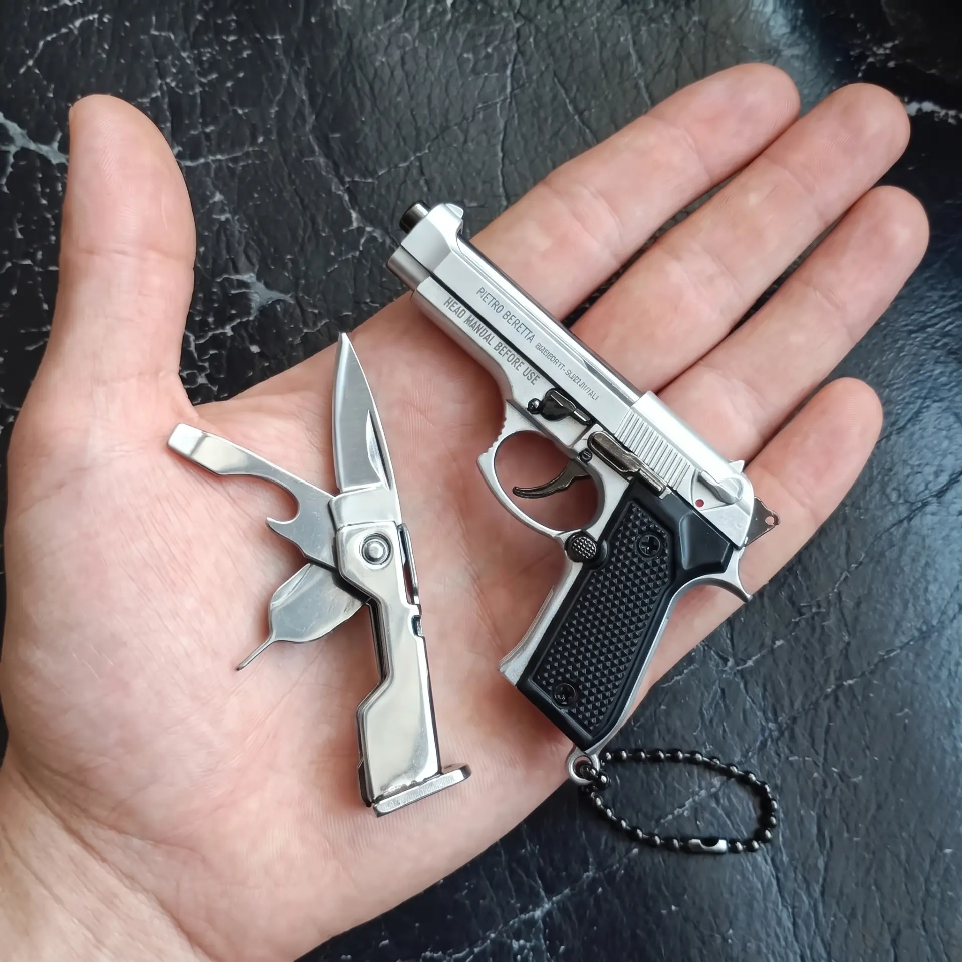 GRIMWERK M92 multi-tool keychain in Chrome finish, held in a palm